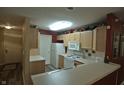 Galley kitchen with light wood cabinets and appliances at 240 Legends Creek Pl # 103, Indianapolis, IN 46229