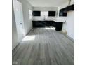 Bright kitchen with black cabinetry, white countertops, and wood-look laminate flooring at 310 S Gerrard Dr, Indianapolis, IN 46241