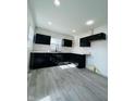 Modern kitchen with black cabinets, white countertop, laminate flooring, and ample natural light at 310 S Gerrard Dr, Indianapolis, IN 46241
