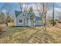 Newly renovated gray house with a light blue door and a grassy yard at 3229 Brill Rd, Indianapolis, IN 46227