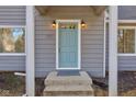 Light blue front door with brass accents and a welcoming stoop at 3229 Brill Rd, Indianapolis, IN 46227