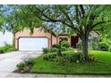 Inviting home exterior with well-kept lawn, mature trees, and a two-car garage at 4646 Rocky Knob Ln, Indianapolis, IN 46254