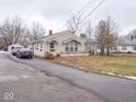 Tan brick ranch house with covered porch and driveway at 6004 S Orinoco Ave, Indianapolis, IN 46227