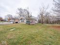 Tan brick ranch home with covered porch and side yard at 6004 S Orinoco Ave, Indianapolis, IN 46227