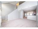 Open-concept living room with neutral carpet, high ceilings, and view of the kitchen area at 6617 Reserve Dr, Indianapolis, IN 46220