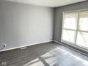 Spacious living room with gray walls, wood-look floors, and large windows at 9508 Conried Dr, Indianapolis, IN 46235