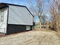 Gravel side yard with chain link fence and mature trees at 9508 Conried Dr, Indianapolis, IN 46235