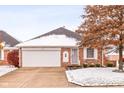 Brick ranch home with attached garage and autumn landscaping; light snow on the ground at 1437 Holiday W Ln, Brownsburg, IN 46112
