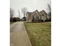 Beautiful two-story home showcasing a brick and stone exterior, complemented by a long driveway and lush lawn at 2504 Fawn Bluff Ct, Zionsville, IN 46077