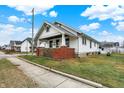Charming home featuring a cozy front porch with brick accents and lush greenery at 403 Colescott St, Shelbyville, IN 46176