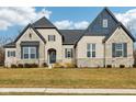 Beautiful brick home with stone accents, a dark roof, dark shutters, and professional landscaping at 5106 Zinnia Dr, Plainfield, IN 46168