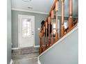 Entryway with a white door, hardwood floors, and a wooden staircase at 55 Markleville Ln, Westfield, IN 46074