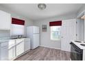 Functional kitchen featuring white appliances, modern flooring, and plenty of counter space at 711 W 24Th St, Anderson, IN 46016