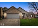 Charming brick and vinyl home with an attached two-car garage and well-maintained front yard at 12525 Wolford Dr, Fishers, IN 46038