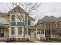 A welcoming yellow home with a covered front porch and beautiful blue accents at 12755 Forsyth St, Carmel, IN 46032
