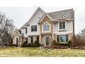 Attractive two-story home boasts a brick and siding exterior and mature landscaping at 13803 Smokey Ridge Dr, Carmel, IN 46033