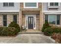 Charming covered front porch featuring a decorative front door and manicured shrubs at 13803 Smokey Ridge Dr, Carmel, IN 46033
