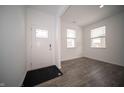 Bright entryway with white walls, gray laminate flooring, and a front door with decorative glass panels at 1407 Foxtail Ln, Greenwood, IN 46143
