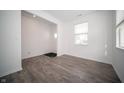 Bright living room with gray laminate flooring, white walls, large window, and plenty of natural light at 1407 Foxtail Ln, Greenwood, IN 46143