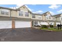 Charming two-story townhome boasts an attached garage, a private patio, and manicured landscaping at 2231 Colfax Ln, Indianapolis, IN 46260