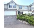 Inviting townhouse showcasing attached garage, neutral siding, and well-maintained landscaping at 2231 Colfax Ln, Indianapolis, IN 46260