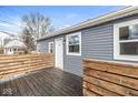 View of the backyard deck with wooden railing, gray siding, and a door leading into the house at 2421 E 11Th St, Indianapolis, IN 46201