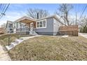 Side view of a home with gray siding, showing the landscaped yard with a wooden retaining wall and concrete steps at 2421 E 11Th St, Indianapolis, IN 46201
