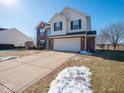 Two-story home showcasing a combination of brick and siding, a spacious driveway, and a landscaped yard at 3143 Shadow Lake Dr, Indianapolis, IN 46217