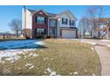 Two-story brick home with attached garage, and a neatly landscaped front yard at 3143 Shadow Lake Dr, Indianapolis, IN 46217