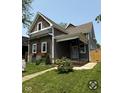 Charming two-story home with gray siding, natural wood accents, inviting front porch, and landscaped yard at 350 E Minnesota St, Indianapolis, IN 46225