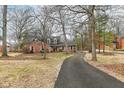 Classic red brick home featuring a long driveway and mature trees providing shade and privacy at 4020 E 71St St, Indianapolis, IN 46220