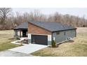 Striking rear exterior shot of a modern home showing the two-car garage and well-manicured backyard at 5802 Watson Rd, Greenwood, IN 46143