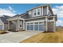 Gray two-story home with a two-car garage, stone accents, and well-maintained landscaping at 6781 Seattle Slew Dr, Whitestown, IN 46075