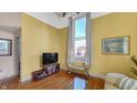 Living room with hardwood floors, yellow walls, and a large TV at 714 Buchanan St # 5, Indianapolis, IN 46203