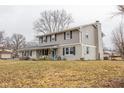 Side view of a two-story house with gray siding, brick accents, and a landscaped lawn at 8139 Hi Vu Dr, Indianapolis, IN 46227
