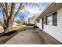 Charming single-story home with white siding, black door, and a concrete walkway at 8815 Frontenac Rd, Indianapolis, IN 46226