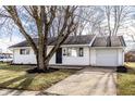 Charming single-story home with white siding, black door, and an attached one car garage at 8815 Frontenac Rd, Indianapolis, IN 46226