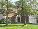 Charming brick home with well-manicured lawn, mature trees, and inviting front porch at 9139 Kelsey Ct, Fishers, IN 46037