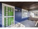 Covered porch with green door and brick flooring at 940 N Chester Ave, Indianapolis, IN 46201