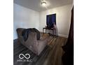 Simple living room with brown couch and dark wood floors at 1154 N Belleview Pl, Indianapolis, IN 46222