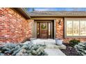 Charming front entrance with a wooden door, decorative wreath, and manicured shrubbery at 1175 Princeton Pl, Zionsville, IN 46077