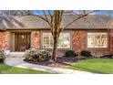Inviting home exterior with a cozy entrance, landscaped garden bed, and classic brick facade at 1175 Princeton Pl, Zionsville, IN 46077