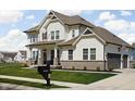 Charming home featuring white siding, a covered porch, three-car garage, and well-maintained landscaping at 16012 Forewood Ln, Fishers, IN 46037