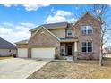 Charming two-story brick home featuring a three-car garage and manicured landscaping at 16457 Anderson Way, Noblesville, IN 46062