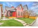 Charming red house with black trim, inviting covered porch, and manicured lawn at 1705 Hoyt Ave, Indianapolis, IN 46203