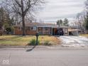 Brick ranch home with carport, basketball hoop, and yard at 2325 Cardinal Dr, Indianapolis, IN 46227