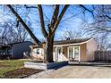 Tan ranch home with large tree in front yard; short, covered porch; and driveway at 3144 Voigt Dr, Indianapolis, IN 46224