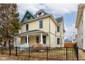 Two story yellow house with a green roof at 317 N Arsenal Ave, Indianapolis, IN 46201