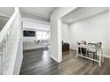 Open view of a neutral-toned office with dark wood floors, a white desk, and adjacent living space at 33 N Highland Knoll Way, Bargersville, IN 46106