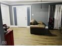 Cozy living room with wood-look flooring, gray walls, and a neutral color scheme at 3306 N Drexel Ave, Indianapolis, IN 46218